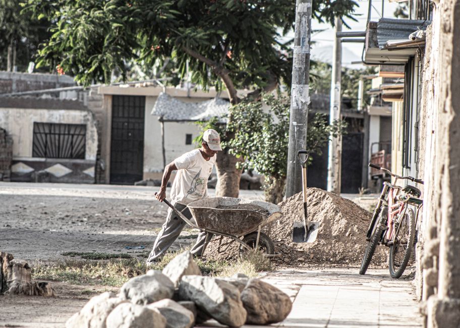 Man working with a wheelbarrow on a sunny day in Zaña, Lambayeque, Peru.